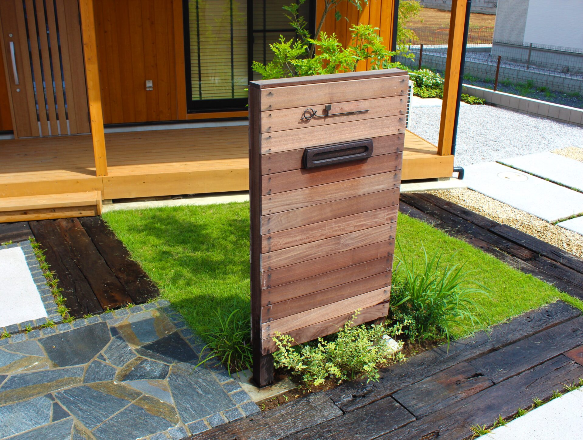 鴻巣市　天然木材のオリジナル門柱と多様な敷材使いと坪庭が特徴のエクステリアの門柱