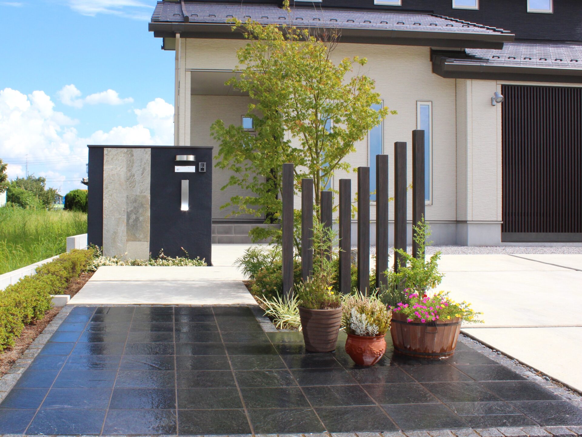 行田市　コントラストが印象的な和モダンスタイルのオープン外構　のアプローチ、雨の日バージョン