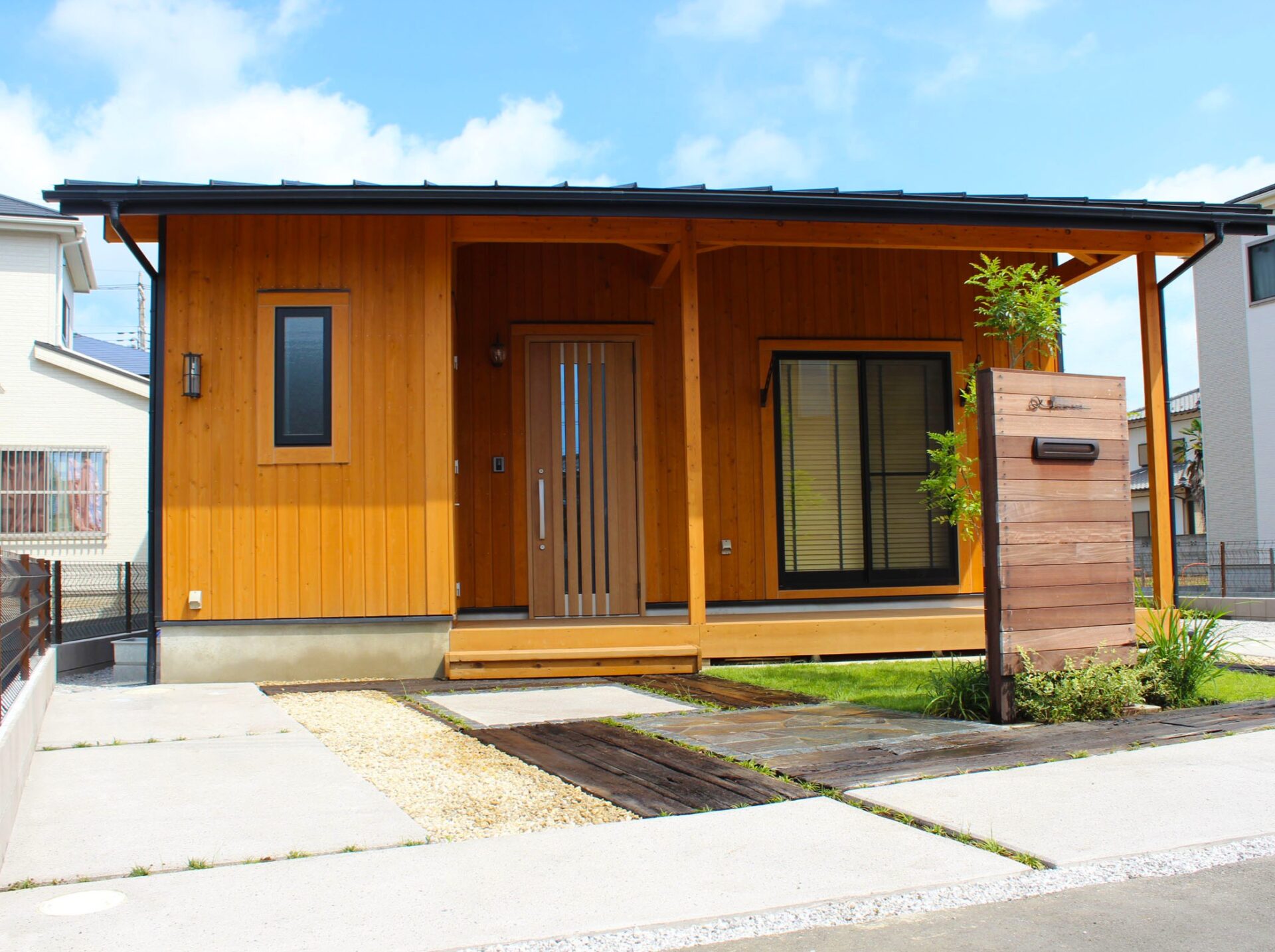 鴻巣市　天然木材のオリジナル門柱と多様な敷材使いと坪庭が特徴のエクステリアの玄関前の駐車スペース