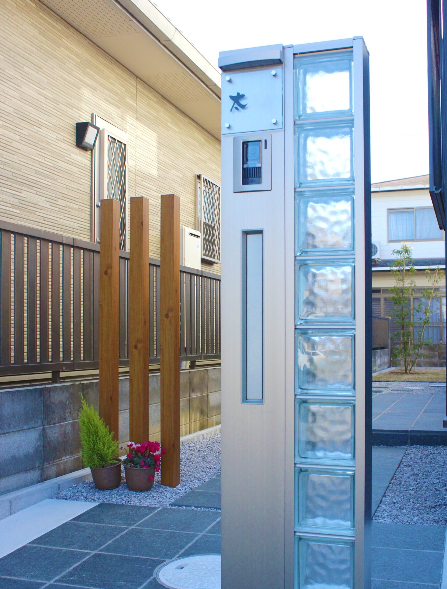 鴻巣市　自然石と黒い玉石のアプローチが建物と調和するオープン外構の機能門柱