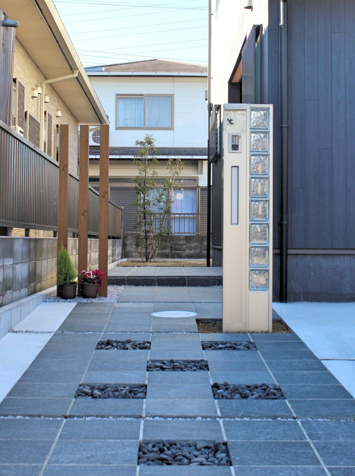 鴻巣市　自然石と黒い玉石のアプローチが建物と調和するオープン外構の門まわり