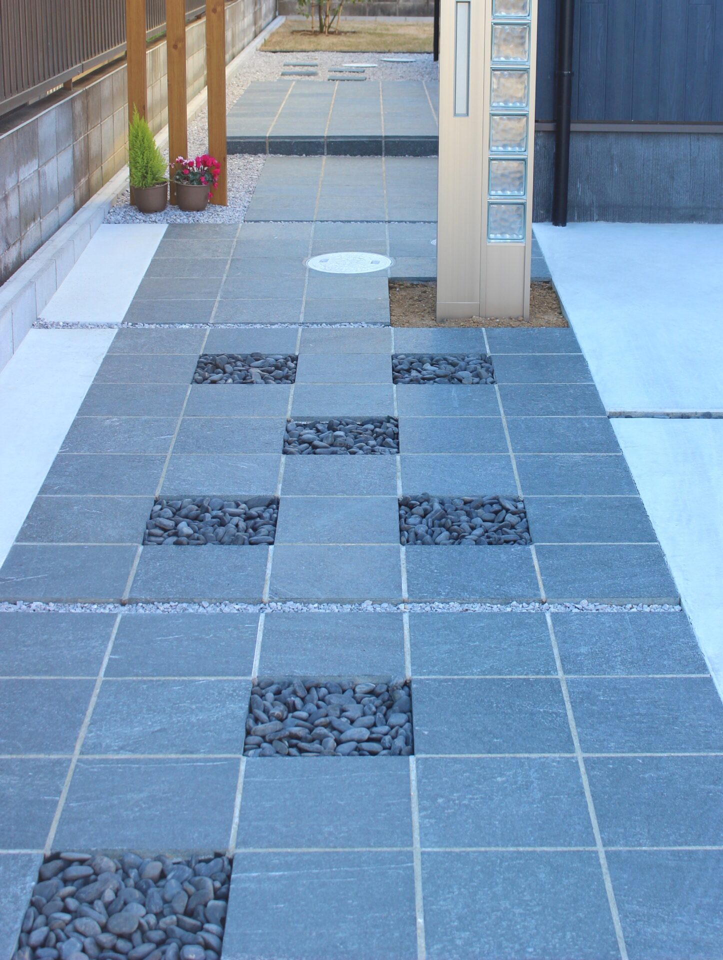 鴻巣市　自然石と黒い玉石のアプローチが建物と調和するオープン外構のアプローチ晴れの日バージョン