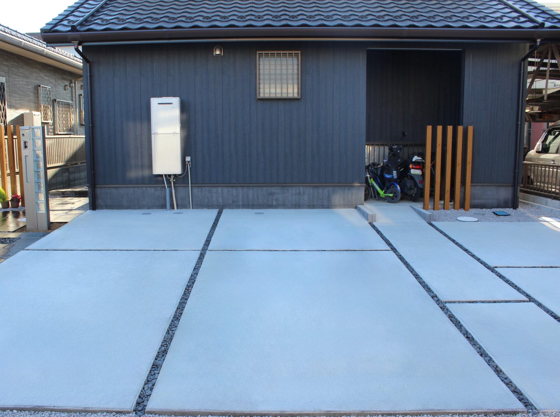 鴻巣市　自然石と黒い玉石のアプローチが建物と調和するオープン外構の駐車スペース