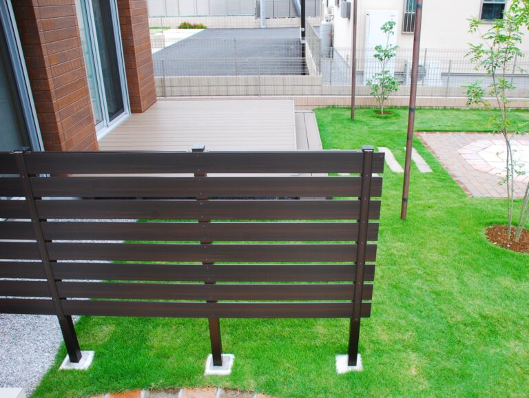 温かい印象の目隠しフェンスとデッキテラス